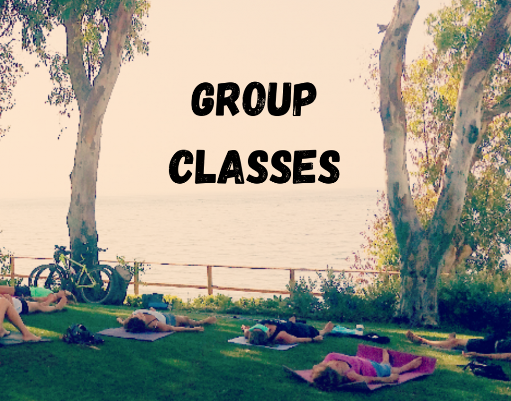 Savasana Yoga Pose on the grass under trees by the sea with text Group Classes