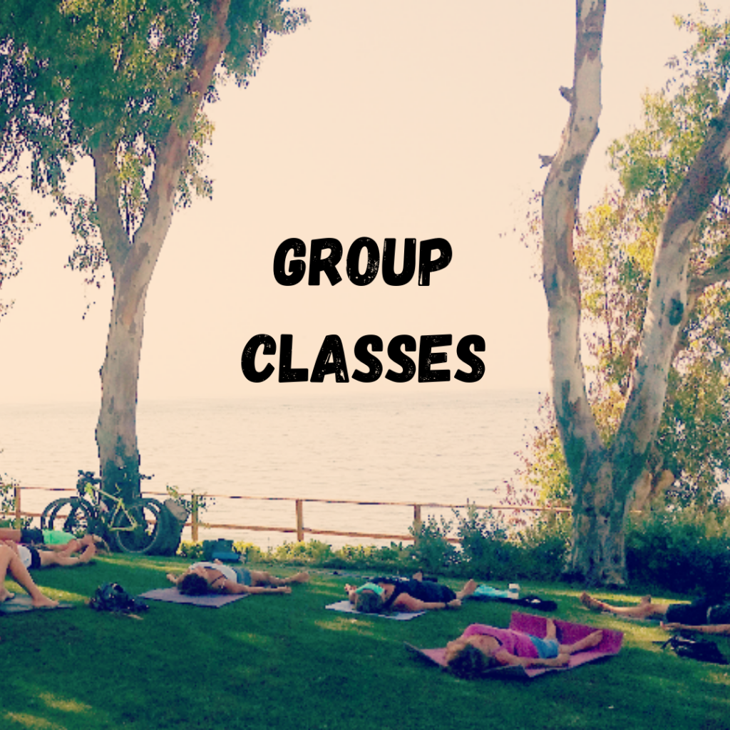 Savasana Yoga Pose on the grass under trees by the sea with text Group Classes